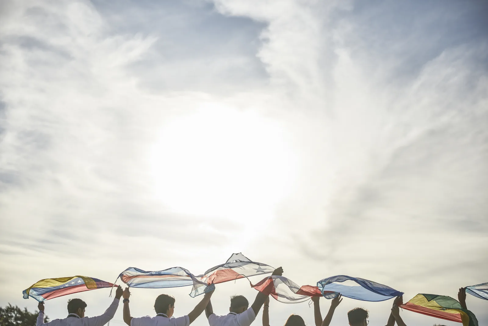 Estudiantes de ProFlight levantando las banderas de sus países hacia el cielo